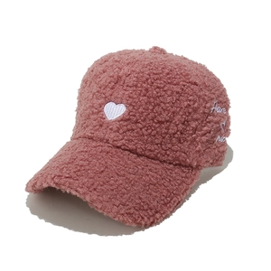 Detail of pink faux shearling baseball cap with white heart and script embroidery