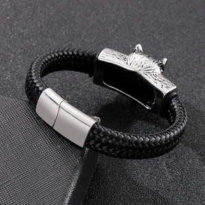 Close-up of a men's black braided leather bracelet with a steel wolf head magnetic clasp