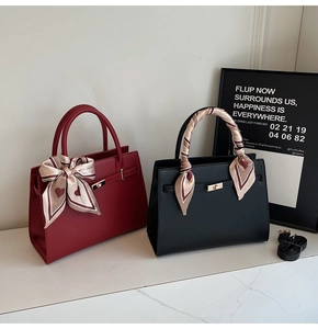 Détail de sacs à main en cuir rouge et noir avec foulards en soie et bandoulières amovibles