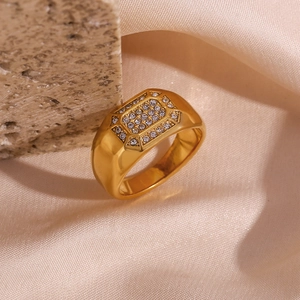 Macro shot of 18K gold plated square ring with zircon inlay on silk background