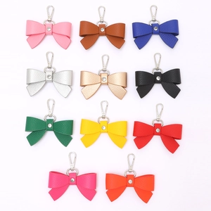 Bow leather keychains in 11 colors with rhinestone and metal clasp on white background
