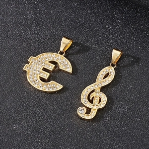 Close-up of gold plated hip hop pendants featuring euro and treble clef music notes