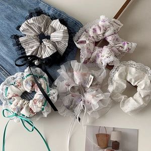 Flat lay of five floral and lace scrunchies with sweet ribbon details and patterns