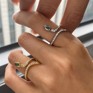 Détail de bagues serpent avec yeux verts et pavage de zircons blancs sur la main