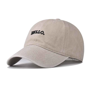 Détail de la broderie HELLO et de la texture du tissu lavé sur la casquette beige