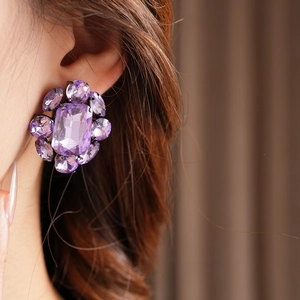 Gros plan de boucle d'oreille flocon de neige vintage avec cristal violet sur l'oreille