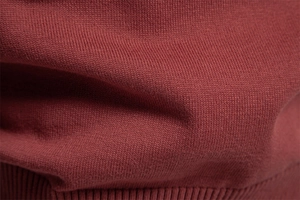 Gros plan sur la maille bordeaux montrant la texture douce et les fibres de coton