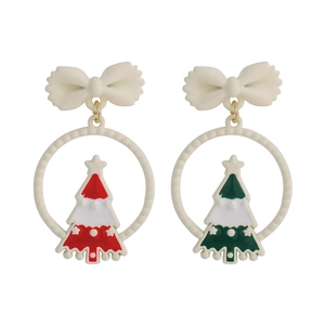 Detail of Christmas tree stud earrings with white bows and red-green enamel finish