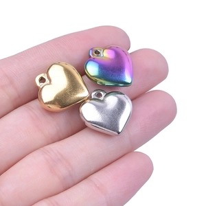 Three 3D heart pendants in gold, silver, and rainbow titanium steel colors