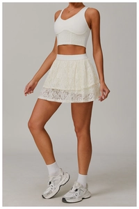 Detailed view of white lace sports corset and layered tennis skirt with fine mesh texture
