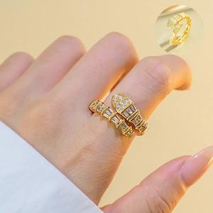 Close-up of a gold-plated snake-shaped ring with pavé crystals on a model's hand