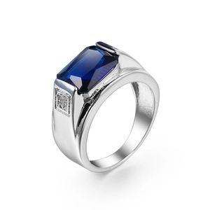 Silver ring with rectangle blue zircon and side stones on a clean white background