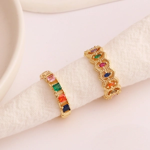 Gold-plated geometric open rings with colorful rainbow zircons on white fabric