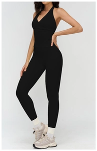 Side view of black brushed yoga set featuring a halter back top and high waist leggings