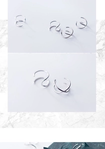 Detail of silver S925 double-layer ear cuffs with minimalist geometric cross lines