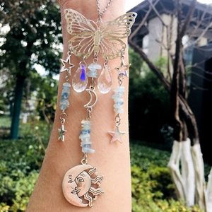 Detail of hanging suncatcher with metal butterfly, moon charms and crystal droplets
