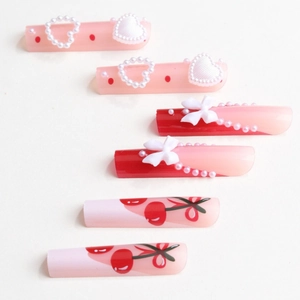 Pink and red press-on nails with 3D pearl hearts, white bows and hand-painted cherries