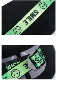 Detail of adjustable black cotton baseball cap featuring green Smile embroidered strap