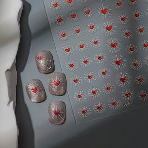 Macro view of Co-537 nail stickers with radiant red hearts on silver glitter nails