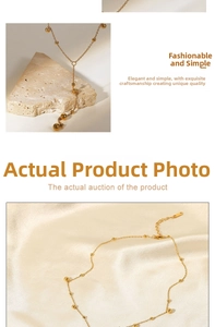Detail of 18K gold-plated beaded chain necklace with long tassel on beige silk background