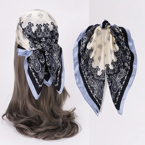 Detailed macro view of vintage paisley square silk scarf in navy blue and cream tones