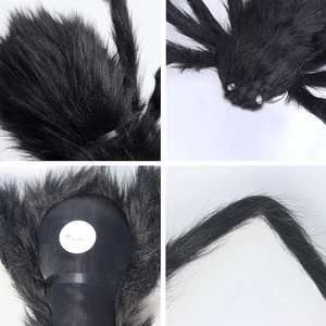 Close-up of black furry Halloween spider showing glowing LED eyes and battery compartment