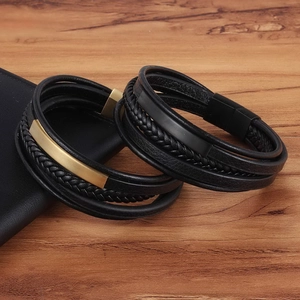 Dettaglio di bracciali in pelle intrecciata con fibbie magnetiche dorate e nere