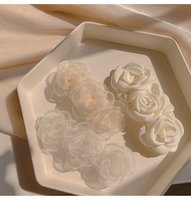 Detailed macro view of camellia hair clips with organza and satin floral textures