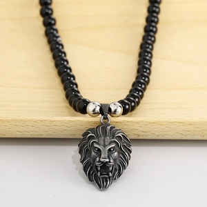 Close-up of 8mm black onyx beads with a detailed stainless steel lion head pendant