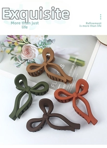 Detail of matte hair claws in four Morandi colors showing strong spring mechanism