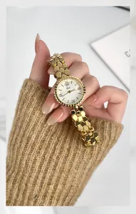 Close-up of golden honeycomb strap and bee logo detail on Gedi women's watch