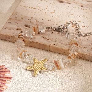 Détail du collier de perles avec pendentif étoile de mer dorée, cristaux et coquillages