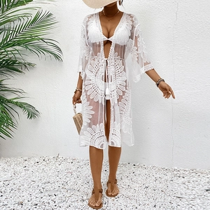 Close-up of white lace embroidery texture and tassel drawstring on beach cover-up