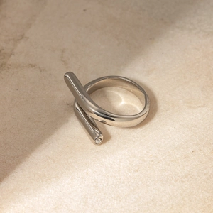 Macro view of silver adjustable intertwined ring featuring a small inlaid gemstone