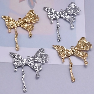Macro view of abstract butterfly charms in gold and silver finish with hanging rings