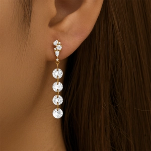 Close-up of long gold fringe earrings with sparkling zirconia crystals on a model