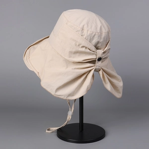 Detail of beige sun hat featuring large brim, decorative bow, and adjustable wind rope