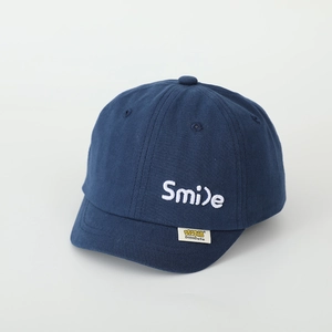 Detail der dunkelblauen Kinder-Basecap mit Smile-Stickerei und gelbem Webetikett
