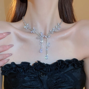 Detailed view of silver butterfly necklace with zircon tassels on a model's neck