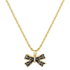 Close-up of gold-plated necklace with black enamel bow pendant and shiny zircon stones