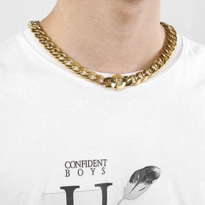Close-up of men's gold stainless steel 13mm Cuban chain with skull clasp on model