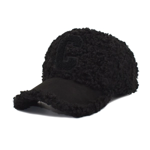 Detail of black lamb wool baseball cap with embroidered letter E and suede brim texture