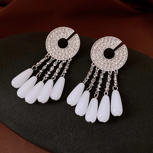Detailed view of silver drop fringe earrings with rhinestones and white teardrop stones