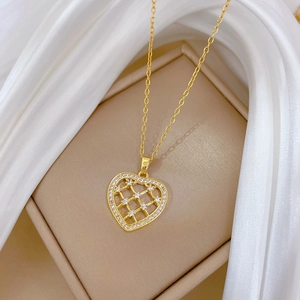 Collier cœur doré ajouré avec cristaux de zircon sur un coffret de présentation de luxe