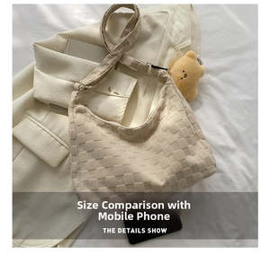 Detail of cream plush woven shoulder bag featuring a cute yellow bear charm pendant