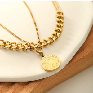 Detailed shot of gold layered coin necklace on a ceramic tray with wood background