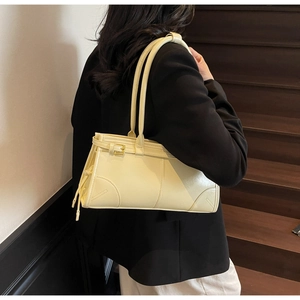 Chic beige PU leather shoulder bag with buckle detail worn on a model in natural light