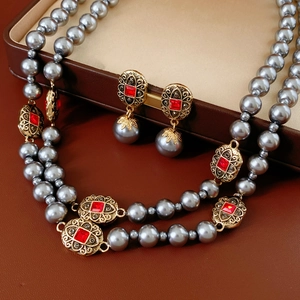 Vintage-Schmuckset mit grauer Perlenkette und roten Edelsteinohrringen in brauner Box