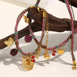 Detailed macro of colorful woven ropes with 18K gold plated sun and heart pendants
