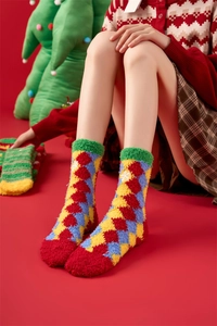 Detailed close-up of fluffy Christmas coral fleece socks with colorful argyle pattern